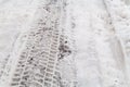 Close-up on tire track imprint on road with snow