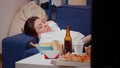 Close up of tired adult laying on couch with TV remote in hand Royalty Free Stock Photo