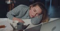 Close up of tired female office worker sleeping in front of opened laptop. Young overworked businesswoman falling asleep Royalty Free Stock Photo