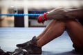 Close Up Of Tired Male Boxer Sitting In Boxing Ring In Gym After Training Session