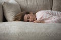 Tired woman has nap lying on sofa looks without energy