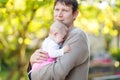 Close-up of tired young father with crying baby girl. Dad with daughter outdoors, love. Tiny child crying. Bonding Royalty Free Stock Photo