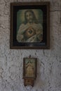 Close up to an antique jesus christ paint with a small holy mary sculpture