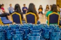 Close up to arranged blue luxury glasses behind the seminar workshop event. Glasses are prepared for the audiences and speakers in