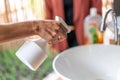 Close up to Asian female hand. she holds the white sprayer / foggy for wash and clean sink at outdoor garden to protect Royalty Free Stock Photo