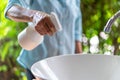 Close up to Asian female hand. she holds the white sprayer / foggy for wash and clean sink at outdoor garden to protect Royalty Free Stock Photo