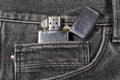 Close up to brushed chrome lighter with windproof over black jeans. Amazing quality and durability. Royalty Free Stock Photo