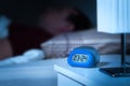 Close up to digital alarm clock on nightstand in bedroom.