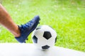 Close up to Football with foot and sport shoe of soccer player. Soccer player control ball on white floor and green blurry