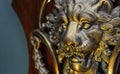 Close up to a golden Iron Lion shiled iluminated with yellow light and a septum piercing jewel Royalty Free Stock Photo