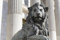 Close up to a guardian lion sculpture at the entrance of madrid congres building with neoclassical pillars architecture style