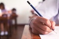 Close up to hand of student is taking exam and writing answer in classroom for education test concept Royalty Free Stock Photo