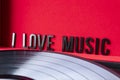 Close up to a I love music lettering over red background with lp vinyl over turntable. Royalty Free Stock Photo