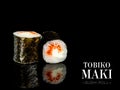 Close up to Maki sushi roll pieces with mirror reflection on black background. Sushi roll with flying fish roe Tobiko, cream Royalty Free Stock Photo