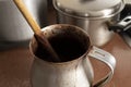 Close up to an old dirty cocoa cooking pot over kitchen furniture with others cooking pots at background Royalty Free Stock Photo