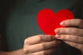 Close-up to red heart in hands. Woman holding paper heart on her chest background Royalty Free Stock Photo