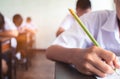 Close up to School student is taking exam and writing answer in classroom for education test concept Royalty Free Stock Photo
