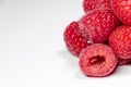 Close-up to several raspberries on white background. Healthy food, natural antioxidants.