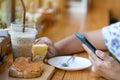 Close up to slices of toast bread and butter with steamed Thai tea custard topping in hand of woman using fork to eat for Royalty Free Stock Photo