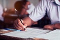 Close-up to student holding pencil and writing final exam in examination room or study in classroom.Vintage style Royalty Free Stock Photo