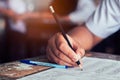 Close-up to student holding pencil and writing final exam in examination room or study in classroom.Vintage style Royalty Free Stock Photo