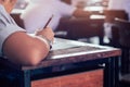 Close-up to student holding pencil and writing final exam in examination room or study in classroom.Vintage style Royalty Free Stock Photo