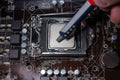 Close up to technician squeezing or application the thermal paste compound on the top of main cpu in the socket. Concept of