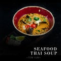 Close up to traditional Thai Tom Yum seafood soup served in bowl isolated on black background. Ready advertising banner with text Royalty Free Stock Photo