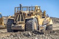 A Close up to a twin engine scrapers on a construction site during the summer