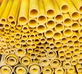 Close up to yellow plastic pipe background, PVC pipes stacked in warehouse Royalty Free Stock Photo