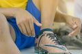 Close up to Young man sit to tying studded laces