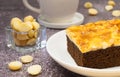 Close up toffee chocolate cake slice on plate with macadamia seeds and coffee cup on stone background for dessert break Royalty Free Stock Photo
