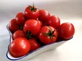 Close-up on tomatoes in a porcelain bowl on a white background