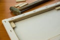 close-up of the tool of the artist stretching the canvas with a hammer wooden spacers for frames. Royalty Free Stock Photo