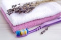 Close up of a toothbrush with lavender toothpaste on a background of lilac towels