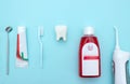 Close up of a toothbrush, toothpaste, irrigator, mouthwash for teeth, dental mirror with white molar tooth model on blurred blue Royalty Free Stock Photo