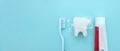 Close up of a toothbrush and toothpaste with white molar tooth model and Protective vortex around tooth on blurred blue background