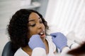 Close- up top angle view of face of attractive African woman patient being checked by dentist in clinic. Female dentist Royalty Free Stock Photo