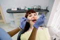 Close-up top angle view of face of attractive European woman patient being checked by dentist in clinic. Female African Royalty Free Stock Photo