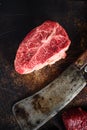 Close up top blade steak cut near butcher cleaver knife on a rustic metall background top view layflat Royalty Free Stock Photo