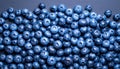 A close-up, top-down view of a large pile of fresh, ripe blueberries on a dark surface Royalty Free Stock Photo