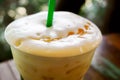 Close up top of Ice Latte and view of Latte art on milk froth on green leave background