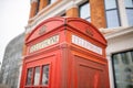 Close up of the top of a London telephone booth and a brick building behind it Royalty Free Stock Photo