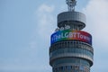 Close up of the top part of the iconic BT Tower, lit up in rainbow colours to celebrate the Gay Pride Parade in London.