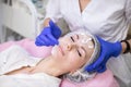 Close up top shot of pretty young lady, receiving skin treatment at beautician office. Hands of doctor cosmetologist Royalty Free Stock Photo