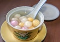 Close up top side view of red, orange and white tangyuan tang yuan, glutinous rice dumpling balls in white bowl.