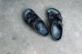 Close up a top veiw of a black leather slippers on cement floor background Royalty Free Stock Photo