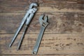 Close-up top view of adjustable wrench and pipe wrenches on a wooden background. Tool for the repair of plumbing pipes and communi Royalty Free Stock Photo