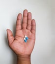 Close up top view on an African male hand holding two pills Royalty Free Stock Photo