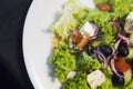 Close up top view on a caesar salad with chicken fillet and parmesan cheese, onion, olives, salad. Royalty Free Stock Photo